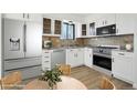 Modern kitchen featuring stainless steel appliances, white cabinetry, and a dining area at 2633 Mather St, Brighton, CO 80601