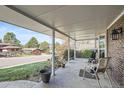 Inviting covered porch with seating area perfect for relaxing and enjoying neighborhood views at 8633 E Monmouth Pl, Denver, CO 80237