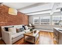 Inviting living room with exposed brick wall, hardwood floors, and comfortable seating at 160 Jackson St # 5, Denver, CO 80206