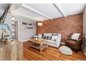 Cozy living room featuring exposed brick, hardwood floors, and comfortable seating at 160 Jackson St # 5, Denver, CO 80206