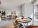Dining area with a round table, stylish chairs, and bright natural light from the window at 8378 S Upham Way # A102, Littleton, CO 80128