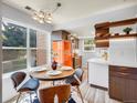 Bright kitchen featuring a round dining table, stylish chairs, and a unique orange refrigerator at 8378 S Upham Way # A102, Littleton, CO 80128