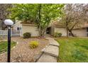 Charming townhouse exterior with landscaped front entrance, gravel and concrete pathway and decorative lamppost at 2459 S Xanadu Way # B, Aurora, CO 80014