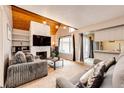 Cozy living room with stone fireplace, wood-beam ceilings, and comfortable seating with sliding glass door at 2459 S Xanadu Way # B, Aurora, CO 80014