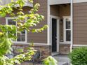 Close up of townhome entry with stone accents and a well-lit porch area at 1456 Sepia Ave, Longmont, CO 80501