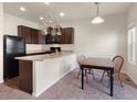 Open kitchen featuring dark cabinets, black appliances, and an adjacent dining area at 1456 Sepia Ave, Longmont, CO 80501