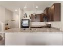 Modern kitchen features stainless steel appliances, dark cabinets, and a breakfast bar for easy dining at 1456 Sepia Ave, Longmont, CO 80501