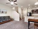 Cozy living room features neutral carpet, a ceiling fan, and open access to the kitchen and staircase at 1456 Sepia Ave, Longmont, CO 80501