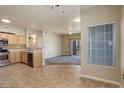 Open-concept kitchen and living room with tile flooring, stainless steel appliances, and natural light at 1016 Opal St # 102, Broomfield, CO 80020