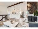 Bright living room with hardwood floors, stone wall accents, modern lighting, and an open floor plan at 17979 E Oxford Pl, Aurora, CO 80013