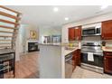 Modern kitchen with stainless steel appliances and a breakfast bar overlooking the cozy living room at 810 S Vance St # C, Lakewood, CO 80226