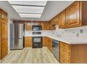 Well-lit kitchen with stainless steel appliances, light countertops and wood cabinets at 13961 E Marina Dr # 409, Aurora, CO 80014