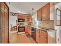 Traditional-style kitchen with wood cabinets, black appliances, and warm lighting at 2038 S Hoyt Way, Lakewood, CO 80227