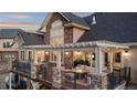 Beautiful home with a multi-level deck, pergola, stone accents, and comfortable outdoor seating areas at 948 Buffalo Ridge Rd, Castle Pines, CO 80108