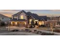 Charming home with stone accents, three-car garage, and manicured front yard at 948 Buffalo Ridge Rd, Castle Pines, CO 80108