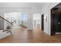 Elegant hallway with arched doorways leading to the living room, kitchen, and a stairway to the left at 948 Buffalo Ridge Rd, Castle Pines, CO 80108