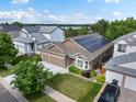 An eye-level aerial of a home featuring solar panels, a three-car garage, and manicured landscaping at 5660 S Eaton St, Littleton, CO 80123