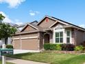Charming home showcasing well-kept landscaping, a three-car garage, and traditional design elements at 5660 S Eaton St, Littleton, CO 80123
