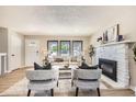 Bright living room with large windows, fireplace, and neutral decor creates a warm and welcoming atmosphere at 3750 S Fairplay Way, Aurora, CO 80014