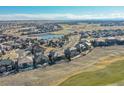 An aerial view of a beautiful community with lush landscaping, a serene lake, and well-maintained homes at 27655 E Moraine Dr, Aurora, CO 80016