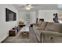 Comfortable living room features neutral colored walls, a ceiling fan and a large sectional sofa at 2279 S Lewiston St, Aurora, CO 80013