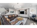 Elegant living room with hardwood floors, a decorative chandelier, and comfortable leather seating at 2627 Hillcroft Ln, Castle Rock, CO 80104
