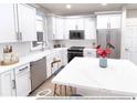 Modern kitchen with white cabinetry, stainless steel appliances, and marble countertop at 1606 W 166Th Ave, Broomfield, CO 80023