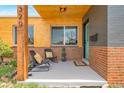Inviting front porch with wood ceilings, chairs, potted plants and a painted brick accent wall at 1320 Locust St, Denver, CO 80220