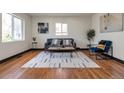 Bright living room with hardwood floors, a gray sofa, patterned rug and a small accent table at 1320 Locust St, Denver, CO 80220