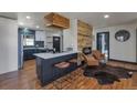 Open living room with hardwood floors, a modern fireplace, a kitchen view, and natural light at 1320 Locust St, Denver, CO 80220