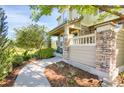 Charming porch with stone pillars, cozy seating and a well-manicured garden at 8835 Edinburgh Cir, Highlands Ranch, CO 80129