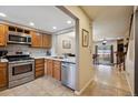 The kitchen features wood cabinets, stainless steel appliances, tile countertops, and an open layout overlooking the dining area at 4117 S Mobile Cir # C, Aurora, CO 80013