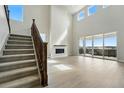 Bright living room with large windows, fireplace, and a staircase at 5722 Farrier Pt, Castle Rock, CO 80104