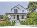 Charming two-story home featuring a covered front porch and manicured lawn, a welcoming facade at 3019 Chase St, Wheat Ridge, CO 80214