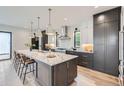 Modern kitchen featuring a large island with barstool seating and a suite of stainless steel appliances at 3019 Chase St, Wheat Ridge, CO 80214