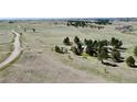 Wide aerial view of a home on a large grassy lot with distant mountains and a winding road at 1740 Michael Gates Dr, Parker, CO 80138