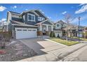 Exterior view of a charming two-story home showcasing its driveway and well-manicured lawn at 2889 Windridge Cir, Highlands Ranch, CO 80126