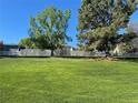 Lush green backyard with mature trees and a wooden fence, ideal for outdoor enjoyment at 1121 W Kettle Ave, Littleton, CO 80120