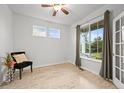 Bright bedroom features wood floors, a ceiling fan, and a view of trees at 42225 Kingsmill Cir, Elizabeth, CO 80107