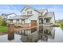 Two-story home with a brick-accented facade, covered porch, and wet driveway at 42225 Kingsmill Cir, Elizabeth, CO 80107