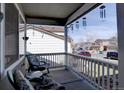 Inviting front porch showcasing comfortable seating and decorative wind chimes at 9659 Autumnwood Pl, Highlands Ranch, CO 80129