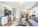 Cozy living room with hardwood floors, fireplace, and open access to the dining area at 3656 W 77Th Ave, Westminster, CO 80030