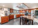 Traditional kitchen with wooden cabinetry, stainless steel appliances, and a dining table at 17595 E Wesley Pl, Aurora, CO 80013