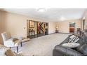 Open-concept living room with a staircase, neutral walls, and cozy seating area at 17595 E Wesley Pl, Aurora, CO 80013