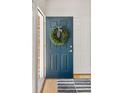 Stylish front door with decorative wreath, leading into a bright entryway with hardwood floors at 10511 Jaguar Gln, Lone Tree, CO 80124