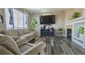 Cozy living room featuring modern fireplace, large windows and plush seating at 14873 E 119Th Ave, Commerce City, CO 80603