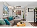 Comfortable living room with modern decor, featuring a large sectional sofa, and a dining area near bright windows at 701 Emporia St, Aurora, CO 80010