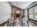 Bright living room featuring a brick fireplace, hardwood floors, and lots of natural light at 17372 E Prentice Cir, Centennial, CO 80015