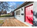 Cozy home exterior showcasing a vibrant red door, a wooden porch, and neat landscaping at 2237 S Lowell Blvd, Denver, CO 80219