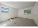 A bright, carpeted bedroom with two windows for natural light and white walls at 8555 Fairmount Dr # A108, Denver, CO 80247